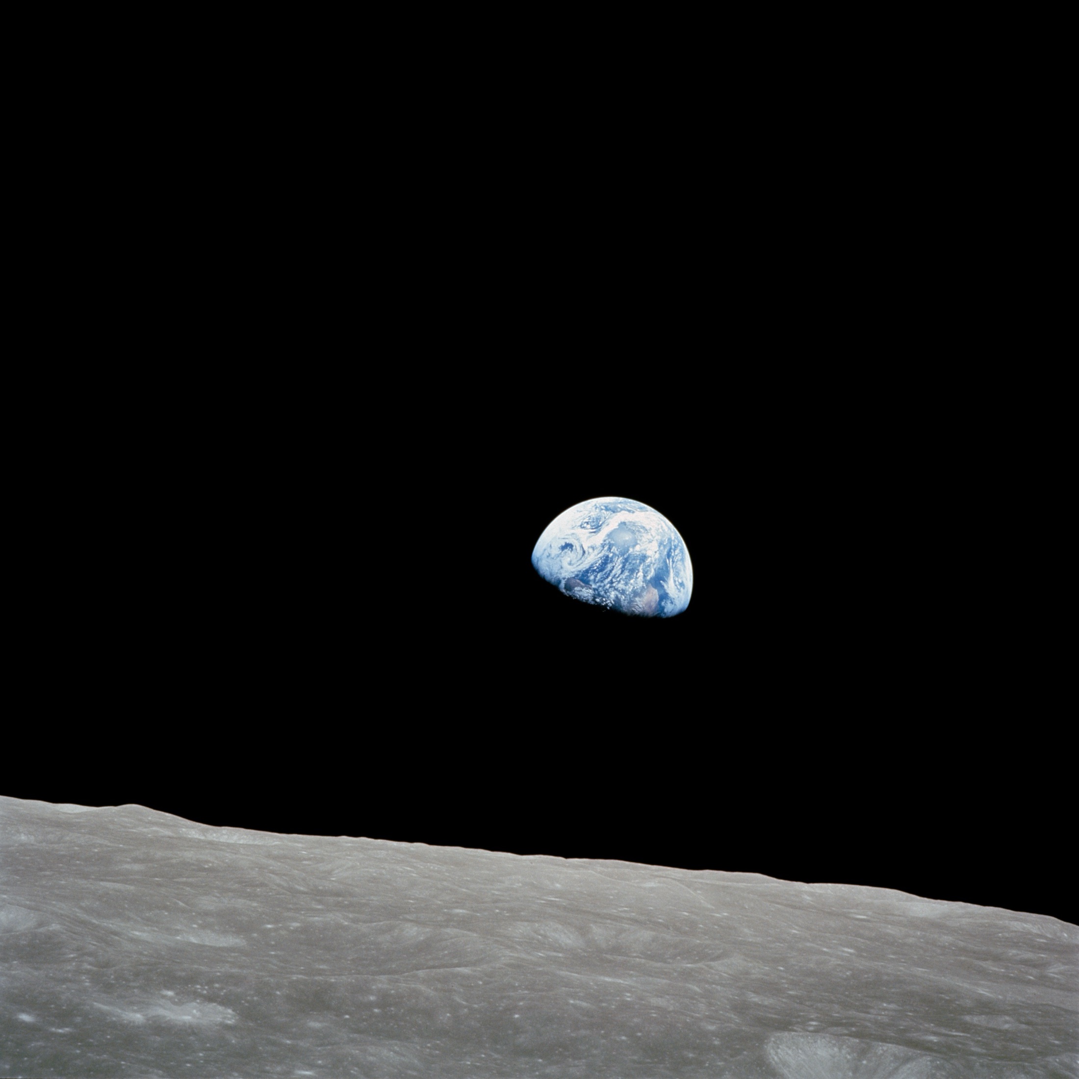 Earth rising over the lunar horizon